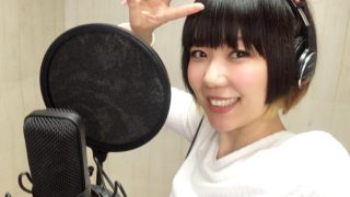 おかっぱミユキの歌のレコーディング風景写真。コンデンサーマイクを前に笑顔でピースサインしている。