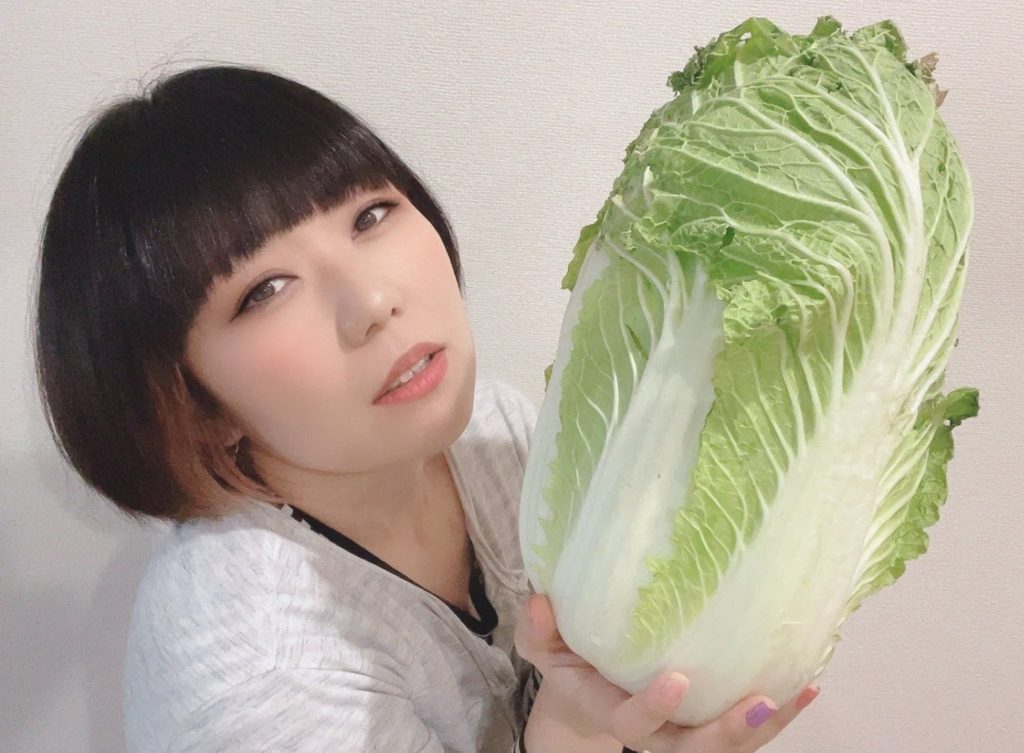 白菜を持つおかっぱミユキの写真。白菜の大きさにうっとりしている様な表情をしている。