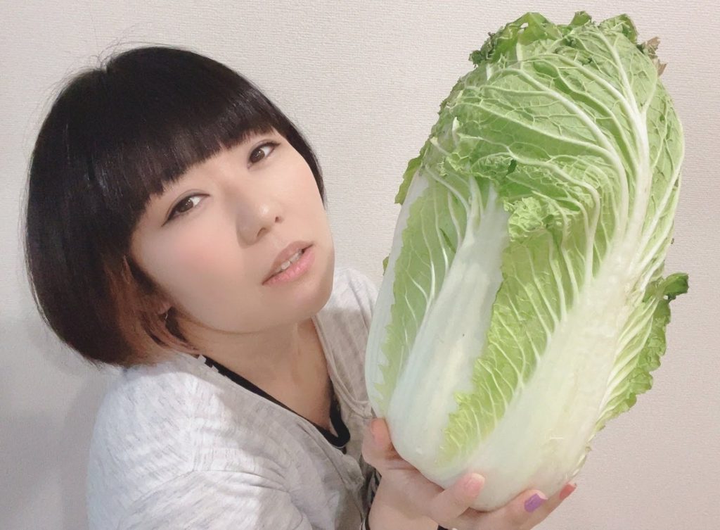 白菜を持つおかっぱミユキの写真。白菜の大きさにうっとりしている様な表情をしている。